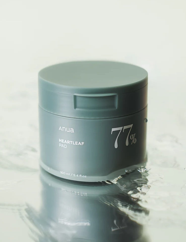 Green jar of Anua Heartleaf 77% Clear Pad floating on water, highlighting its soothing and hydrating skincare benefits.