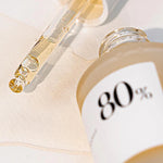 Close-up of the Anua Heartleaf Soothing Ampoule with a dropper tip, showcasing its texture on a white surface.