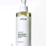 A bottle of Anua Heartleaf Pore Control Cleansing Oil with a pump top and sleek white design, highlighting ingredients on the label, set on a water-like background.
