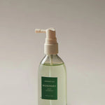 Clear pump bottle of Aromatica Rosemary Root Enhancer hair treatment, shown on a neutral background.