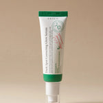 A tube of Axis-Y Dark Spot Correcting Glow Serum with a green cap, set against a neutral background.