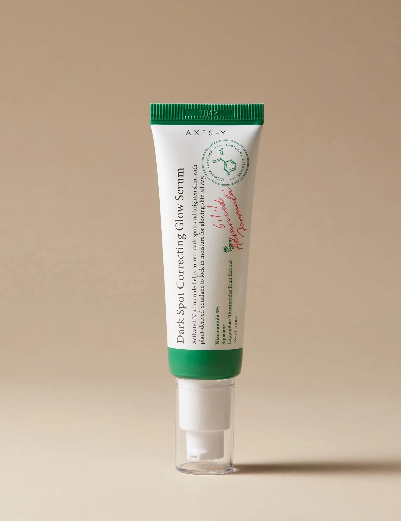 A tube of Axis-Y Dark Spot Correcting Glow Serum with a green cap, set against a neutral background.