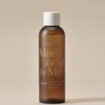 Brown glass bottle of AXIS-Y Biome Comforting Infused Toner labeled 'Made for Me by Me,' set against a neutral background.
