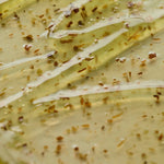 Close-up of glossy, jelly-like texture of AXIS-Y New Skin Resolution Gel Mask with assorted herbs, showcasing key ingredients and reflecting light.