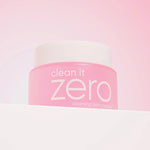 Banila Co Clean It Zero Cleansing Balm Original in a pink jar with a white lid, displayed on a gradient pink background.