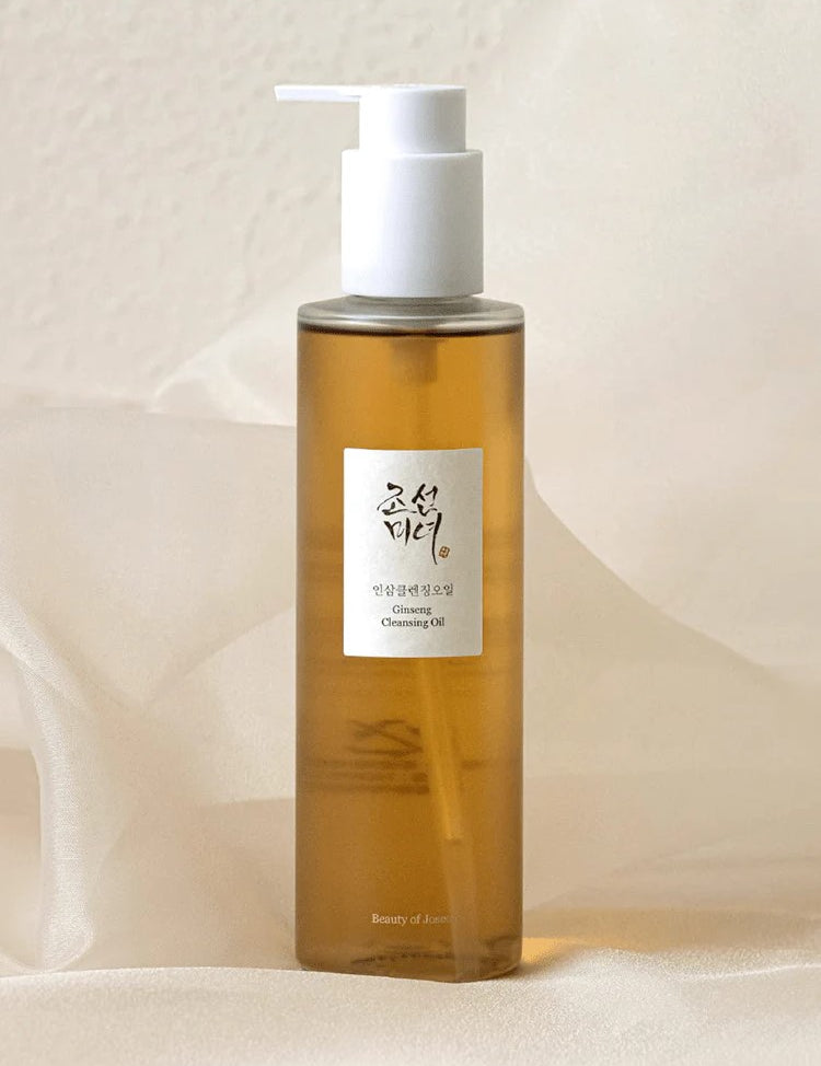Amber bottle of the Beauty of Joseon Ginseng Cleansing Oil with a white pump top, set against a soft, neutral background, featuring a label with the brand logo in Korean text.