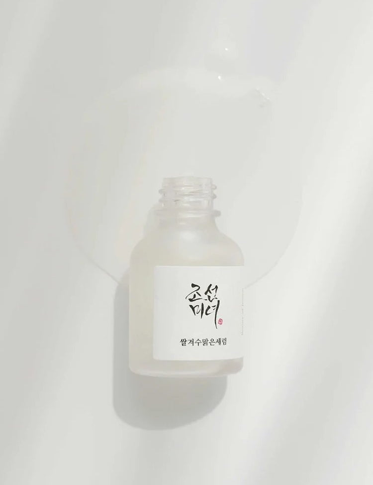 Beauty of Joseon Glow Deep Serum: Rice and Alpha Arbutin with liquid flowing out, showcasing its lightweight texture against a soft white background.