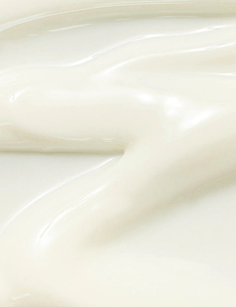 Close-up of 'Beauty of Joseon Relief Sun: Rice + Probiotics' creamy and lightweight texture flowing on a plain surface, showcasing its nourishing formula.