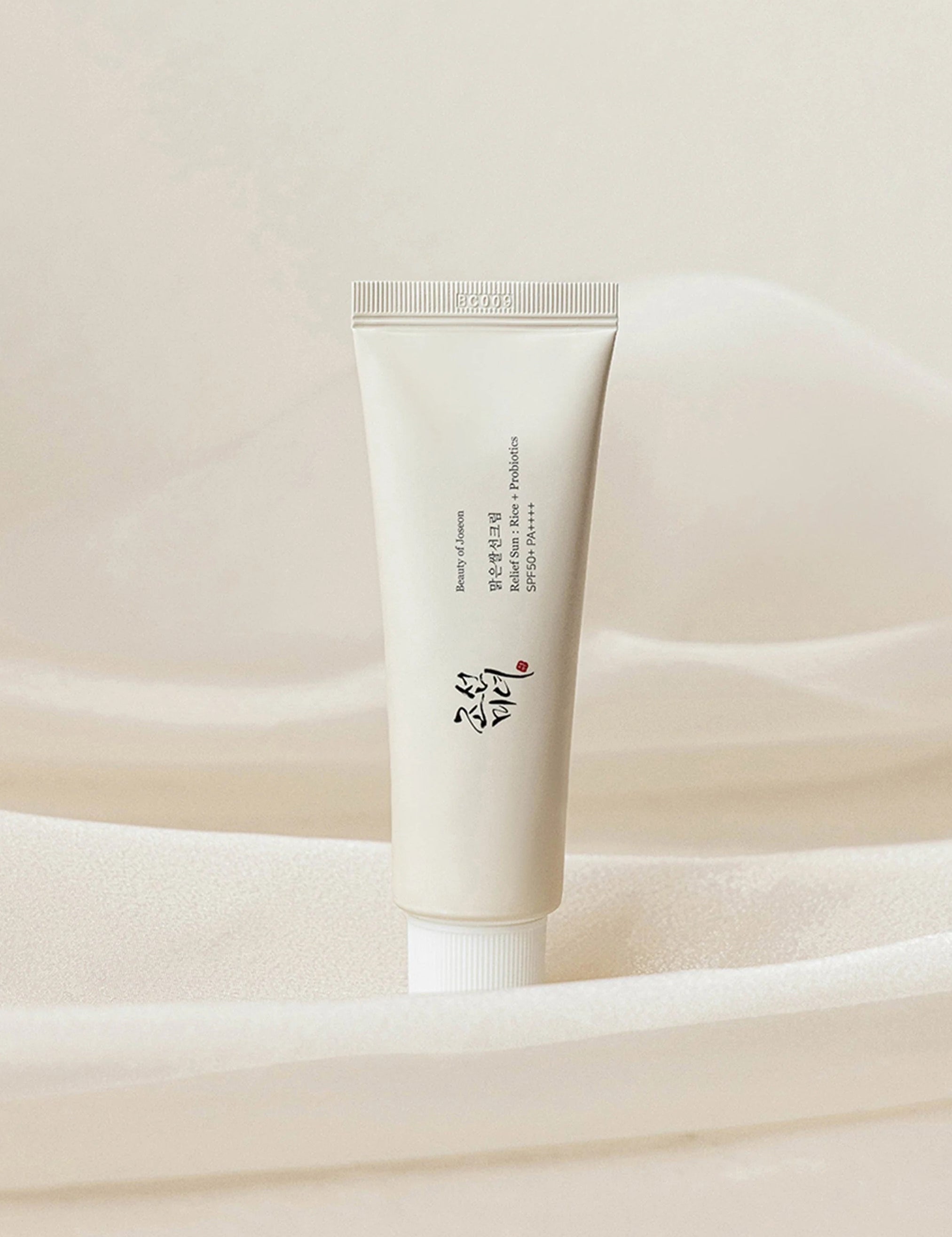 Beauty of Joseon Relief Sun: Rice + Probiotics placed against a soft, textured background, highlighting its elegant design and dual benefits of nourishing skincare and sun protection.