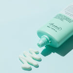 Benton Air Fit UV Defense Sun Cream tube partially squeezed, with a dollop of cream beside it on a pale blue background.