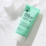 A mint green tube of Benton Air Fit UV Defense Sun Cream lying on a white background with feathers.