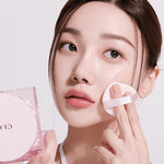 Model with brown hair applying CLIO Kill Cover Mesh Glow Cushion, showcasing radiant glass-skin effect.