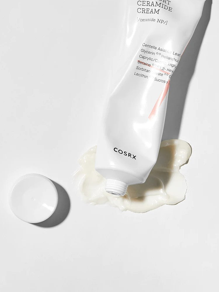 A tube of Cosrx Ceramide Cream lies on a white surface, with its rich, smooth cream oozing out beside a detached cap.