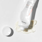 A tube of Cosrx Ceramide Cream lies on a white surface, with its rich, smooth cream oozing out beside a detached cap.