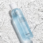 A bottle of Cosrx Hydrium Watery Toner resting on shimmering water, highlighting its refreshing texture with droplets on the surface.