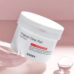 A container of COSRX Original Clear Pad on a pink background, highlighting skincare ingredients like Salix Alba Bark Water and BHA.