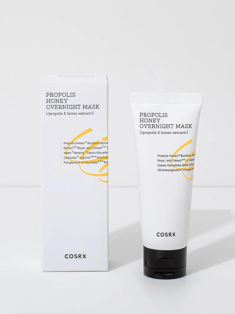 A tube of Cosrx Propolis Honey Overnight Mask placed next to its packaging, showcasing a sleek design and ingredient-focused details.