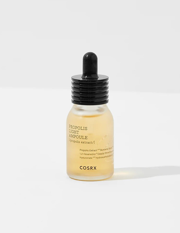 Cosrx Propolis Light Ampoule in a clear glass dropper bottle with a black lid, featuring light amber liquid and minimalistic label design.