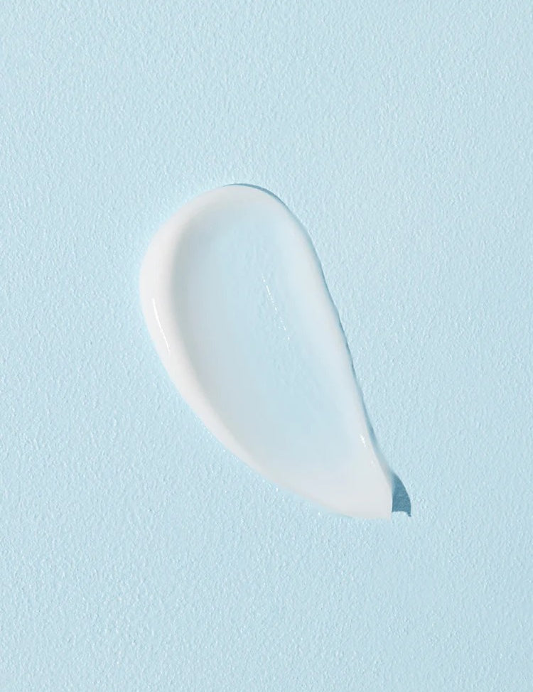 A smooth, glistening white cream droplet on a soft blue background, showcasing the texture of Cosrx Ultimate Nourishing Rice Overnight Spa Mask.