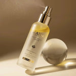 A sleek bottle of d'Alba First Spray Serum with a mist nozzle, set against a soft beige background to evoke luxury and hydration.