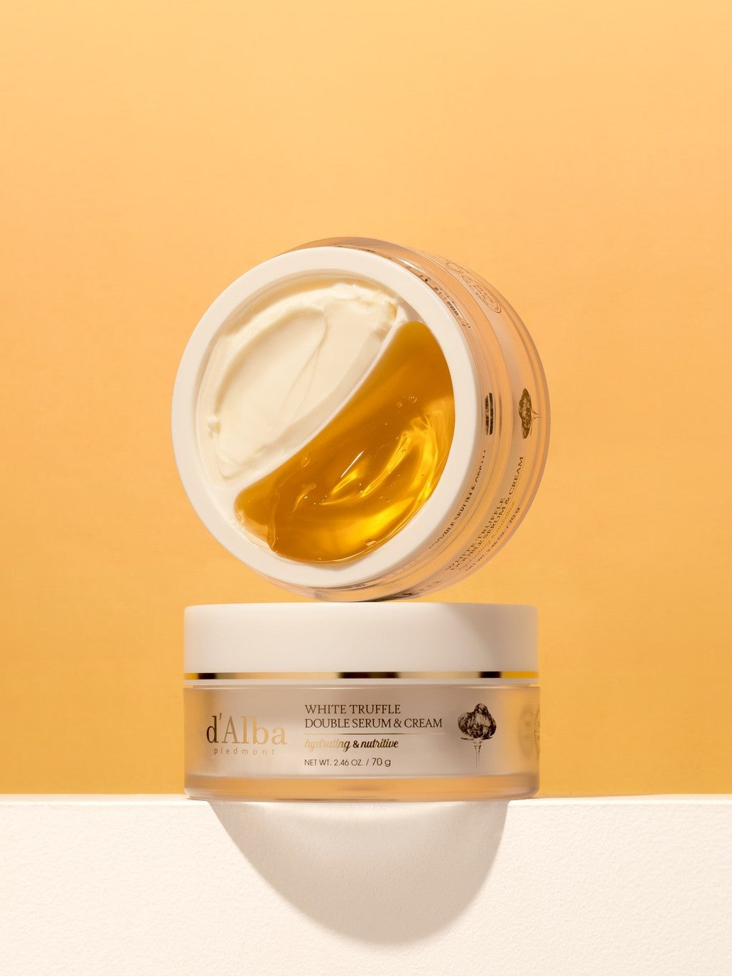 Two jars of d'Alba's White Truffle Double Serum and Cream on a soft orange background, showcasing creamy and golden texture.