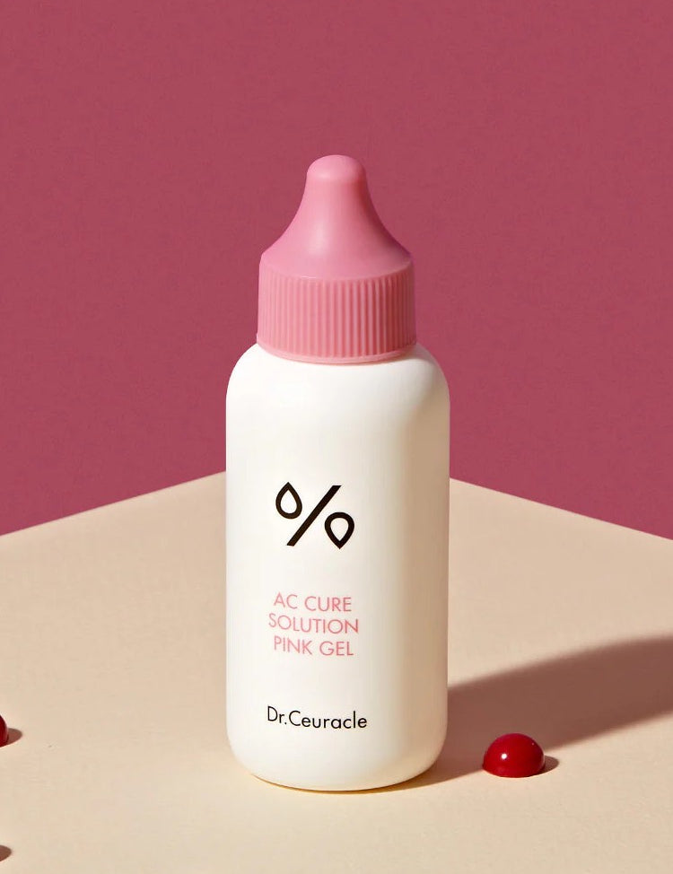 A bottle of Dr. Ceuracle AC Cure Solution Pink Gel on a beige surface, formulated with soothing and acne-targeting properties to address spot concerns effectively.