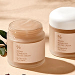 Two jars of Dr. Ceuracle Vegan Kombucha Tea Gel Cream on a beige background, surrounded by dried berries and green leaves, highlighting its antioxidant-rich formula.