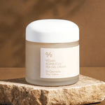 A jar of Dr. Ceuracle Vegan Kombucha Tea Gel Cream on a stone surface, with a warm, blurred background highlighting its lightweight and hydrating formula.