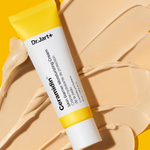 A tube of Dr. Jart+ Ceramidin Skin Barrier Moisturizing Cream resting on a beige smear of its texture against a bright yellow background.