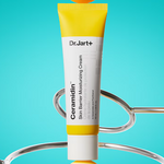 Dr. Jart+ Ceramidin Skin Barrier Moisturizing Cream displayed upright between metallic loops on a vibrant blue background.