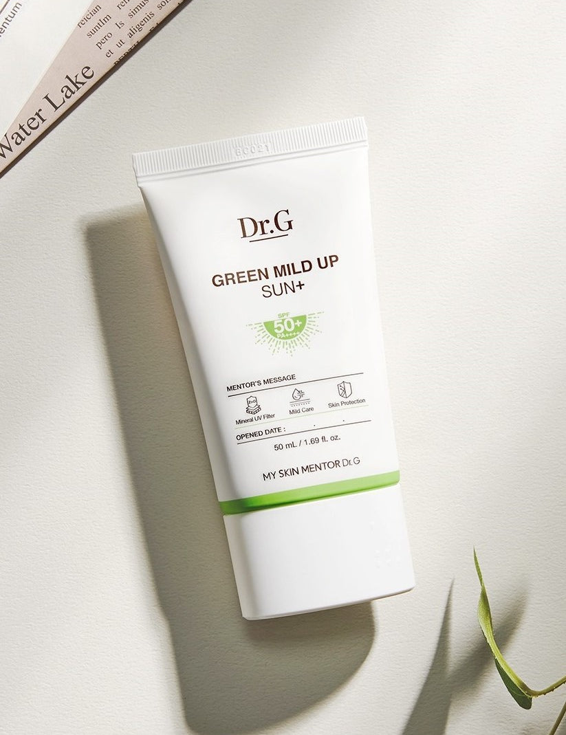 Dr.G Green Mild Up Sun+ Sunscreen SPF 50+ tube on a light surface, showing its white design with green accents and labeled details.