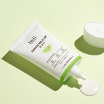 Dr.G Green Mild Up Sun+ Sunscreen tube dispensing a dollop of cream onto a light green background, highlighting its creamy yet lightweight texture.