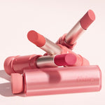 A vibrant arrangement of four pink lipsticks from the Etude House Fixing Tint Bar collection, set against a soft pastel background.