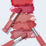 Flat lay of five Etude House Fixing Tint Bar lipsticks in various pink and red shades, with swatches of each color displayed on a white background.