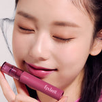 A model holds a lipstick from the Etude House Fixing Tint Collection, showcasing the texture on her lips.