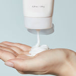 A hand holds a dollop of Etude House Moistfull Collagen Cleansing Foam, showcasing its creamy texture against a light background.