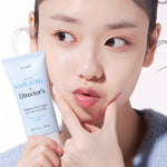 A model holding a tube of Etude House Soon Jung Director Moisture Sun Cream, wearing a light blue sweater in soft lighting.