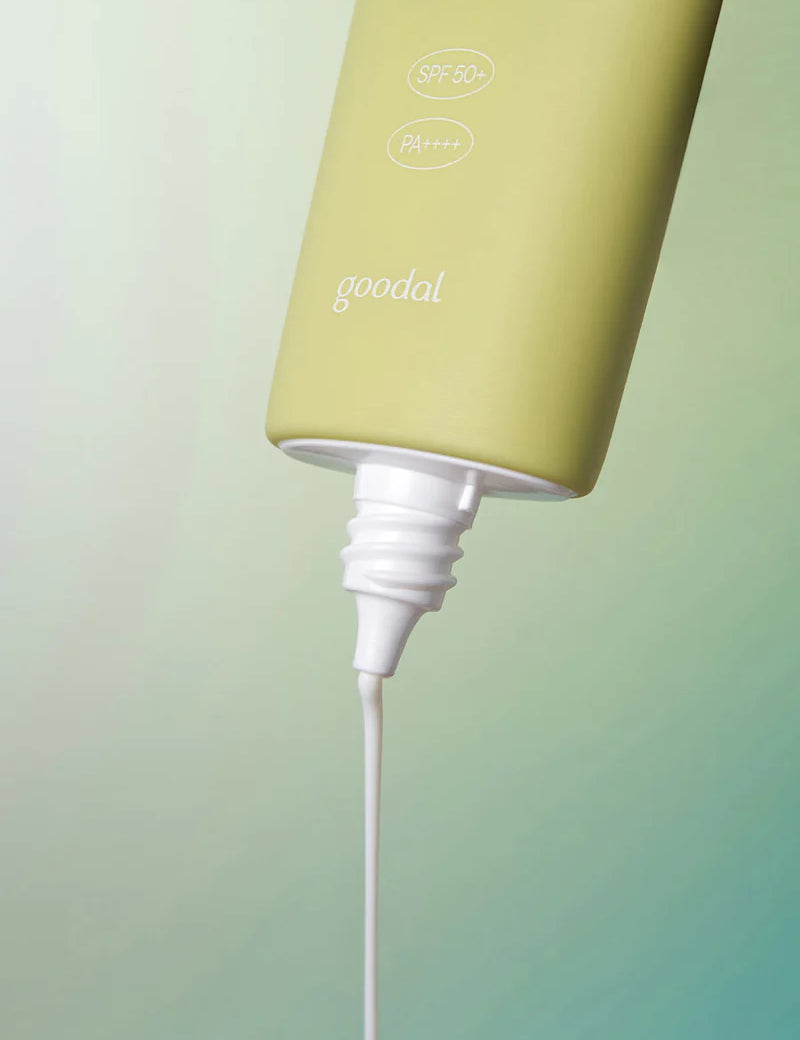 A tube of Goodal Houttuynia Cordata Calming Moisture Sun Cream with SPF 50+ and PA++++ dispensing its creamy white formula against a soft gradient background.
