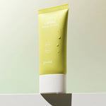 A pastel green tube of Goodal Houttuynia Cordata Calming Moisture Sun Cream with SPF 50+ and PA++++, resting on a white ledge with water droplets.