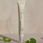 A tube of Haruharu Wonder Bakuchiol Eye Cream set against a soft background with Centella Asiatica leaves nearby, highlighting its soothing ingredients.