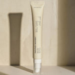 A sleek tube of Haruharu Wonder Black Rice Bakuchiol Eye Cream standing on a softly lit surface against a minimalist background.