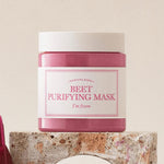 A pink jar of 'I'm From Beet Purifying Mask' displayed on a textured stone pedestal against a soft, neutral background, emphasizing its antioxidant and skin-purifying benefits.