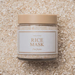 A jar of 'I'm From' Rice Mask placed on a bed of white rice in a wooden bowl, highlighting its main ingredient.