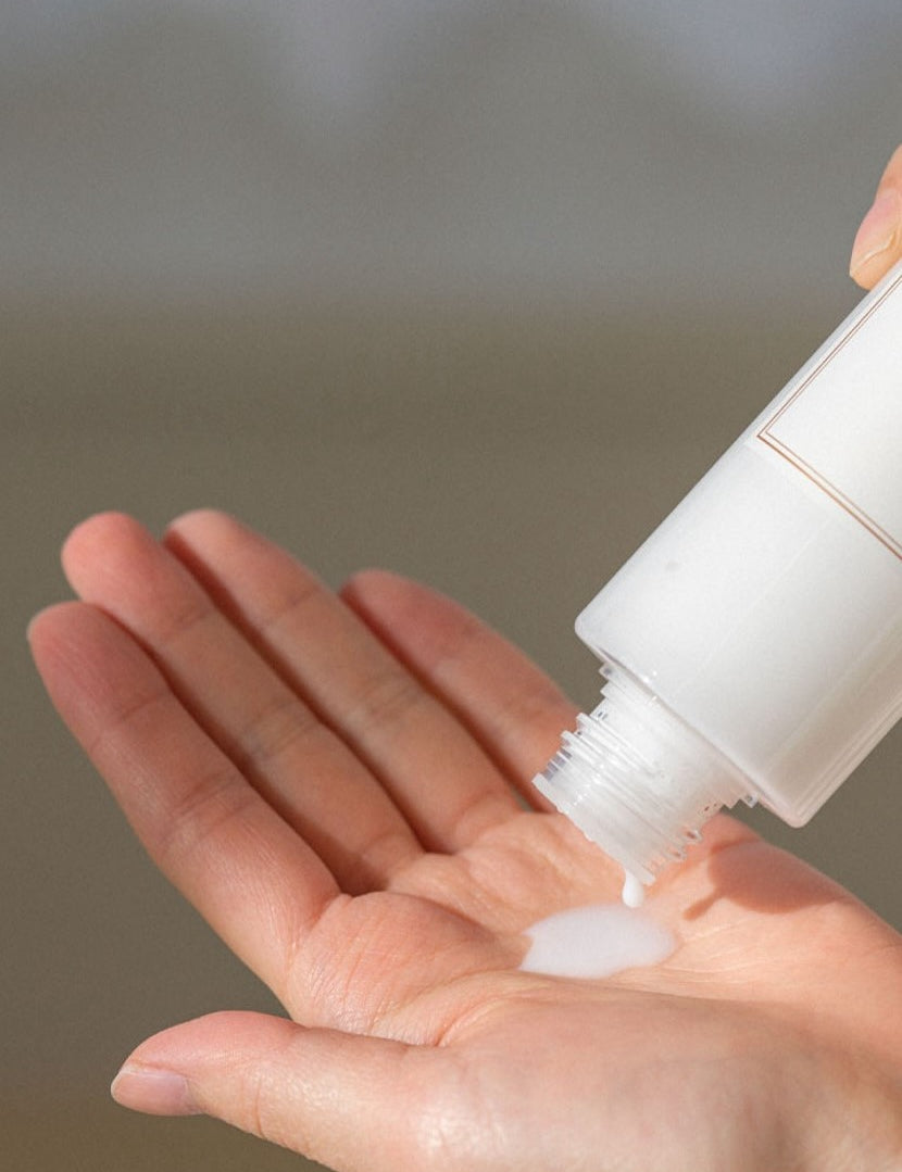 Milky white liquid from the 'I'm From' Rice Toner dripping into a hand held palm.