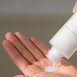 Milky white liquid from the 'I'm From' Rice Toner dripping into a hand held palm.