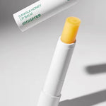 Innisfree Canola Honey Lip Balm with a yellow tip, partially out of the white tube, showcasing its smooth texture and bright yellow color.