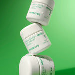 Three Innisfree Green Tea Seed Hyaluronic Cream jars stacked on a vibrant green background, glistening with droplets of water to emphasize hydration and freshness.