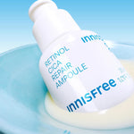 Close-up of Innisfree Retinol Cica Repair Ampoule bottle resting in a pale blue dish, showcasing its smooth texture against a bright background.
