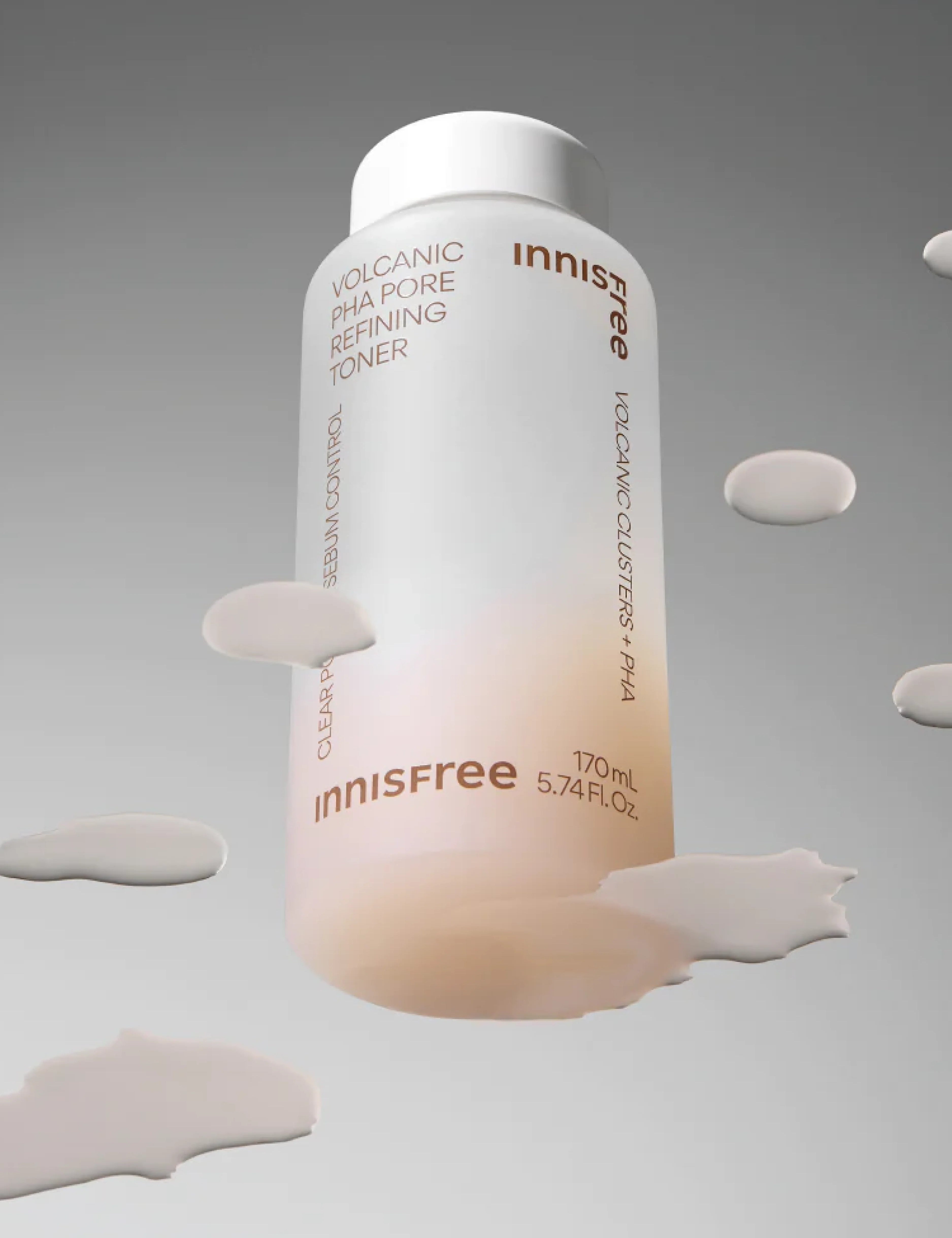 A bottle of Innisfree Volcanic PHA Pore Refining Toner with a white cap, surrounded by its lightweight texture drips against a gradient gray background, emphasizing its refining and sebum-controlling properties.