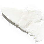 Creamy, buttery texture of Isntree Hyaluronic Acid Airy Sun Stick smeared with a spatula, showcasing its smooth and thick consistency against a plain background.